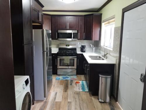 a kitchen with black cabinets and a wooden floor at Inn The Town in Port Antonio