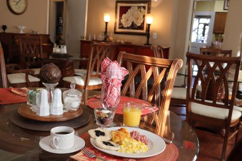 a table with a plate of scrambled eggs and orange juice at 50 Lincoln Short North Bed & Breakfast in Columbus