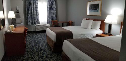 a hotel room with two beds and a window at SureStay Plus Hotel by Best Western Lethbridge in Lethbridge