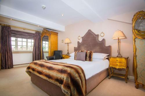 um quarto grande com uma cama grande e uma cadeira em Black Horse Inn em Northallerton
