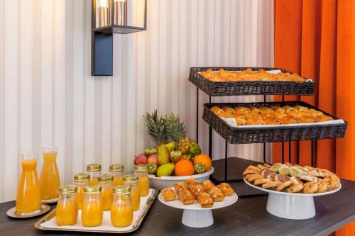 a table with several plates of food and drinks at Hôtel & Spa Les Sept Fontaines Best Western Premier in Tournus