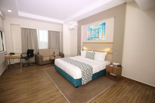 a hotel room with a bed and a desk at PrideInn Plaza Nairobi Airport in Nairobi