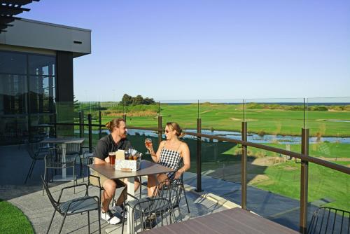 a man and woman sitting at a table on a balcony at Best Western City Sands in Wollongong