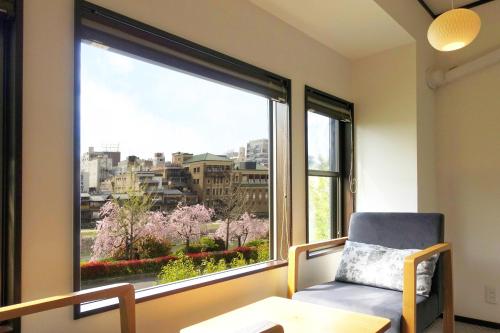 a chair in front of a large window with a view at RESI STAY Gion in Kyoto