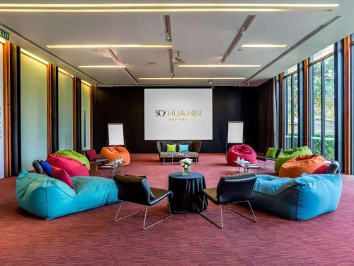 a lobby with couches and chairs and a screen at SO/ Sofitel Hua Hin in Cha Am