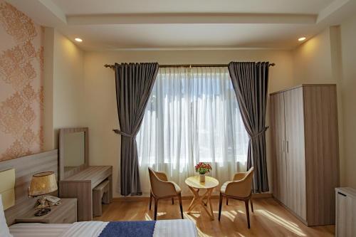 sypialnia z łóżkiem, stołem i oknem w obiekcie Khanh Uyen 1 Hotel w mieście Da Lat