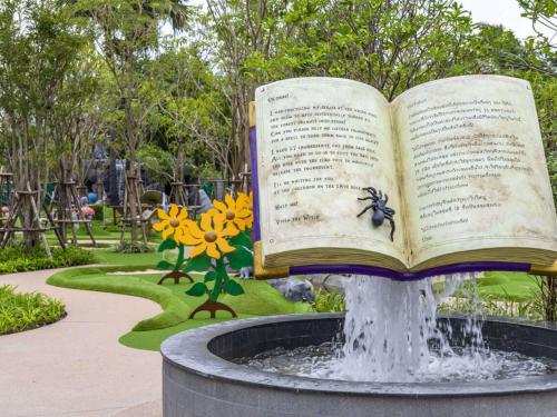 an open book sitting on top of a fountain in a park at SO/ Sofitel Hua Hin in Cha Am