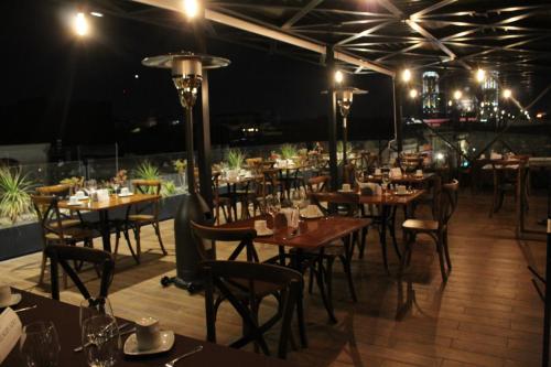 a restaurant with tables and chairs at night at Hotel Diana in Puebla