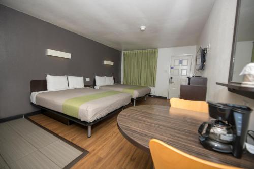 a hotel room with two beds and a table at Studio 6-Tyler, TX in Tyler