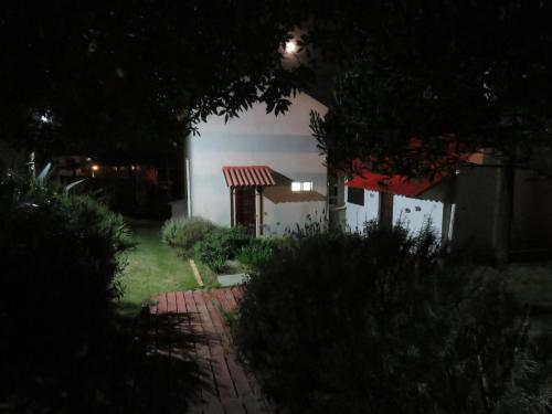 uma casa à noite com um caminho de tijolos na frente em La Ruca em Punta Del Diablo