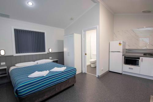 a hotel room with a bed and a refrigerator at Karrinyup Waters Resort in Perth