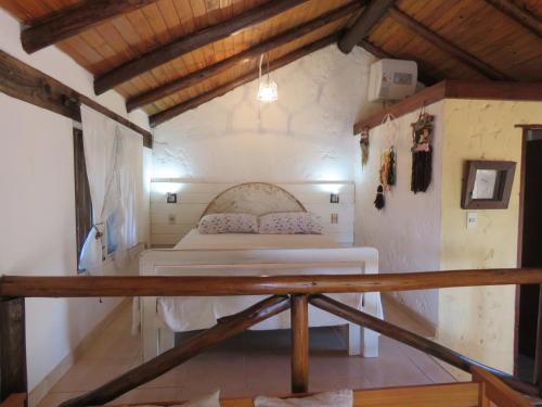 a bedroom with a bed in the corner of a room at La Ruca in Punta Del Diablo