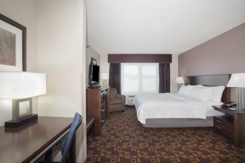 a hotel room with a bed and a desk and a television at Holiday Inn Express & Suites Yankton by IHG in Yankton