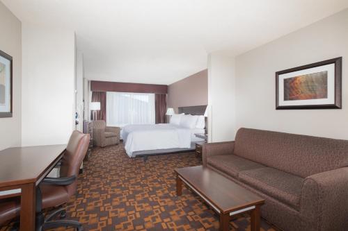 a hotel room with a bed and a couch at Holiday Inn Express & Suites Yankton by IHG in Yankton