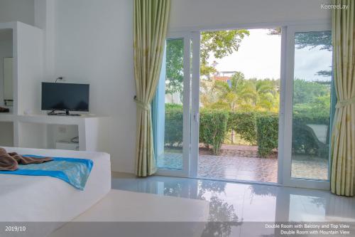 a living room with a white couch and a sliding glass door at KeereeLay --- SHA Extra Plus --- in Ko Lanta