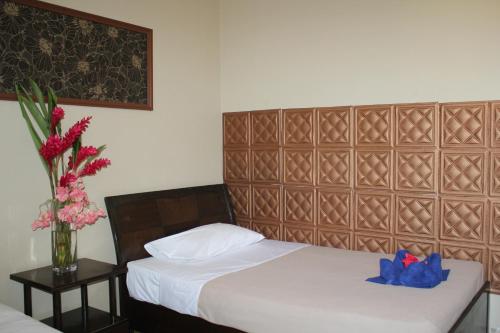 a bedroom with two beds and a vase of flowers at City Lodge in Port Vila
