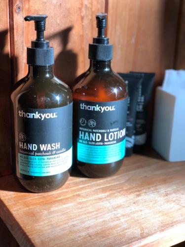 two bottles of hand lotion sitting on a wooden shelf at The Green Room Wattle Glen in Wattleglen