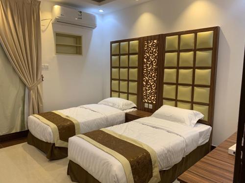 a bedroom with two beds and a window at شقق حدائق الزيتون للوحدات السكنية -اقتصادية in Hail