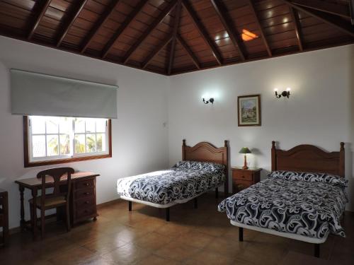 a bedroom with two beds and a table and a window at Casa Mar in Tijarafe