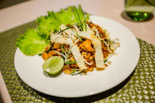 a plate of food with a salad and a lime at The Sanctuary Villa Battambang in Battambang