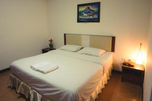 a bedroom with a large bed with two towels on it at The Residence Hotel -SHA Extra Plus in Chiang Mai