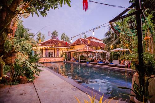 a swimming pool in front of a house at The Sanctuary Villa Battambang in Battambang