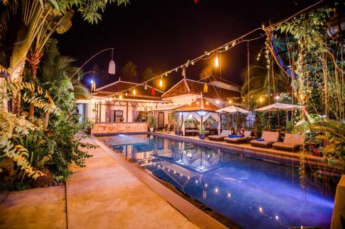 a house with a swimming pool at night at The Sanctuary Villa Battambang in Battambang