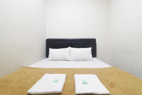 Una cama con dos toallas blancas encima. en Hotel Omah Ampel Syariah en Sukodono