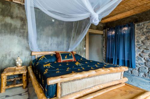 a bedroom with a wooden bed with a canopy at Kivu Paradis Resort in Nyamyumba