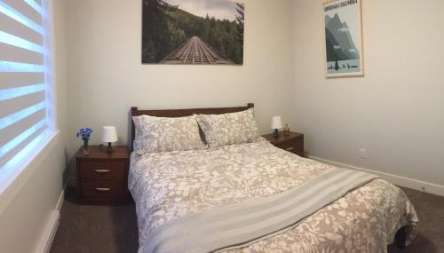 ein Schlafzimmer mit einem Bett mit zwei Nachttischen und einem Fenster in der Unterkunft Mollys Cottage-The Suite on Vancouver Island near YYJ Airport and the WA and BC Ferries in North Saanich