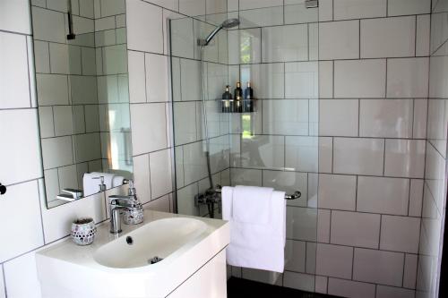 a white bathroom with a sink and a mirror at Villa Kelapa Langkawi in Kuah