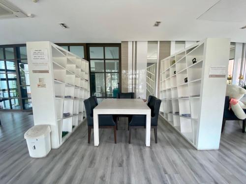 a table and chairs in a room with shelves at Teddy@Thammasart in Pathum Thani