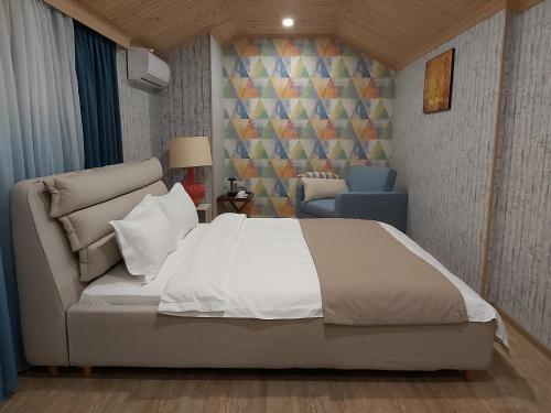 1 dormitorio con 1 cama blanca grande y 1 sofá en VeraNda, en Tiflis