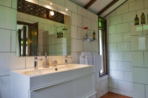 クアにあるVilla Kelapa Langkawiの洗面台と鏡のある白いバスルーム