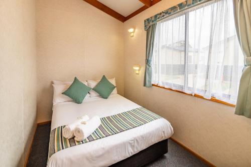a small bedroom with a bed and a window at Ingenia Holidays Nepean River in Emu Plains