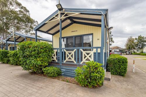 a blue and yellow tiny house in a parking lot at Ingenia Holidays Nepean River in Emu Plains