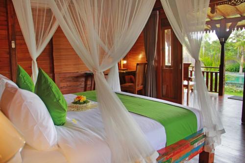 1 dormitorio con 1 cama con dosel en Galang hari villa, en Ubud