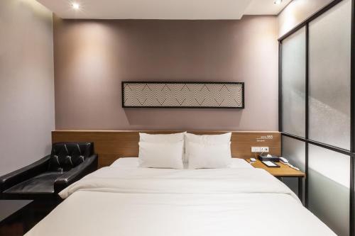 釜山にあるBeomil Brown Dot Hotelのベッドと椅子付きのホテルルーム