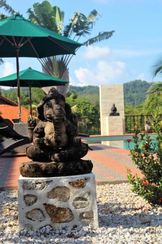 a statue of a woman holding an umbrella at Villa Kelapa Langkawi in Kuah