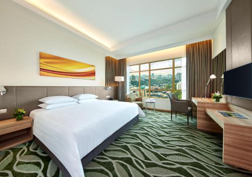 a hotel room with a large bed and a desk at Sunway Lagoon Hotel , formerly Sunway Clio Hotel in Kuala Lumpur