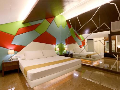 a bedroom with a bed with a colorful wall at Hotel Ava Malate in Manila