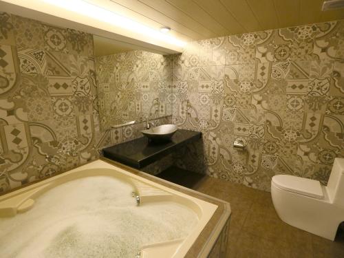 a bathroom with a bath tub and a toilet at Hotel Ava Malate in Manila
