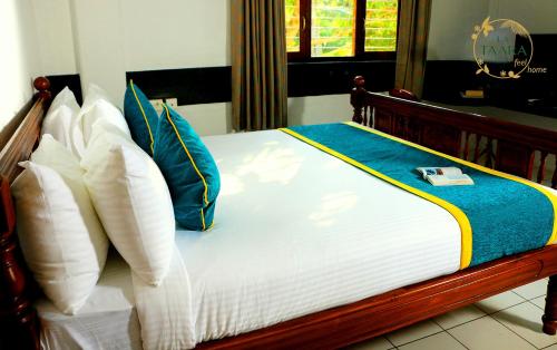 a bed with blue and white pillows on it at La Taara - Feel Home in Auroville