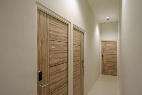 a hallway with a wooden door in a house at RedDoorz @ Jalan Kartini Semarang in Semarang