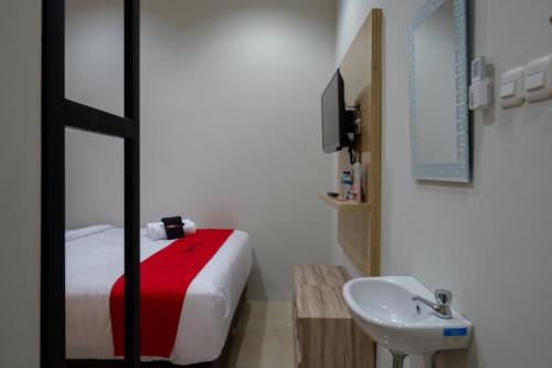 Baño pequeño con cama y lavabo en RedDoorz @ Jalan Kartini Semarang, en Semarang