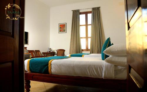 a bedroom with a bed and a window at La Taara - Feel Home in Auroville