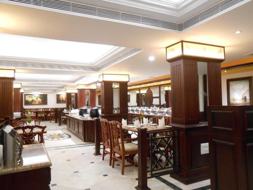 a restaurant with tables and chairs in a room at The South Park Hotel in Trivandrum