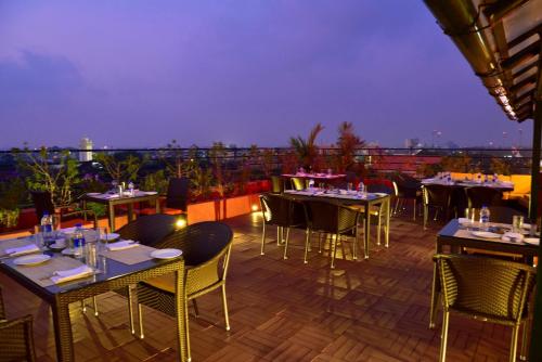 a restaurant with tables and chairs on a roof at The South Park Hotel in Trivandrum