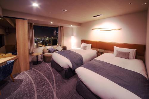 a hotel room with two beds and a window at Hotel Granvia Osaka-JR Hotel Group in Osaka
