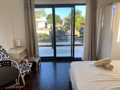 a bedroom with a bed and a large window with a balcony at Villa Ebène - Ideal Location in Rose Hill in Rose Hill